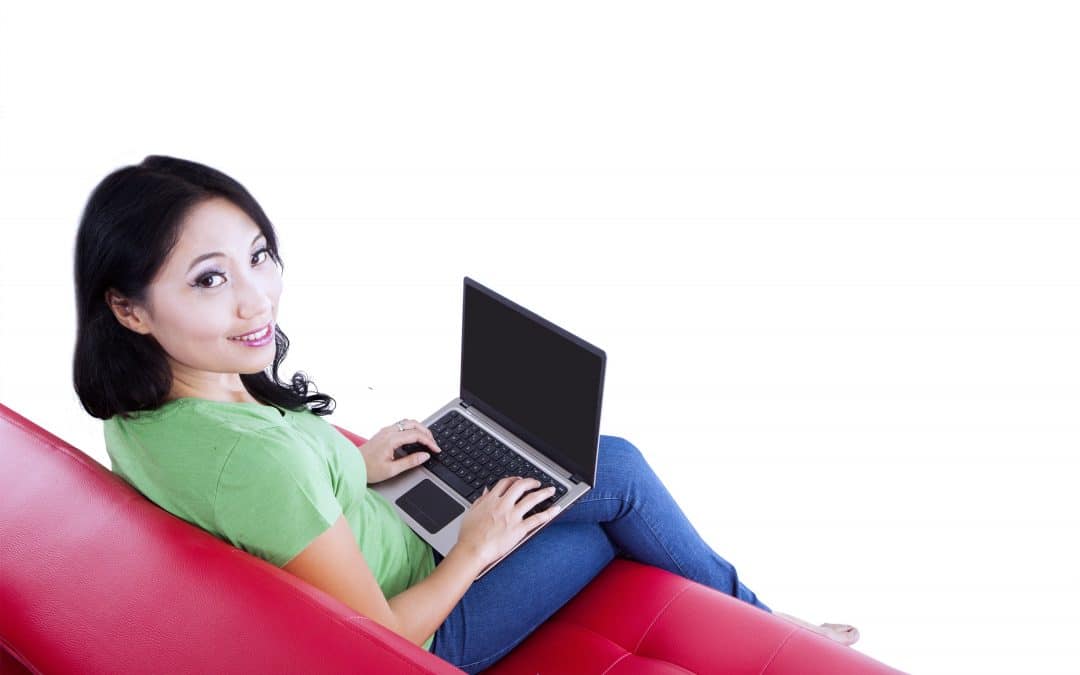 Isolated image of young female typing on red sofa
