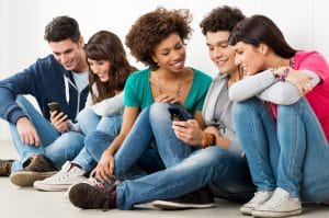 Group of happy young friends looking at cell phone
