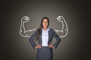 Conceptual Smiling Young Businesswoman Standing in Front Gray Gradient Background with Arm Muscles Drawing, Emphasizing Power.