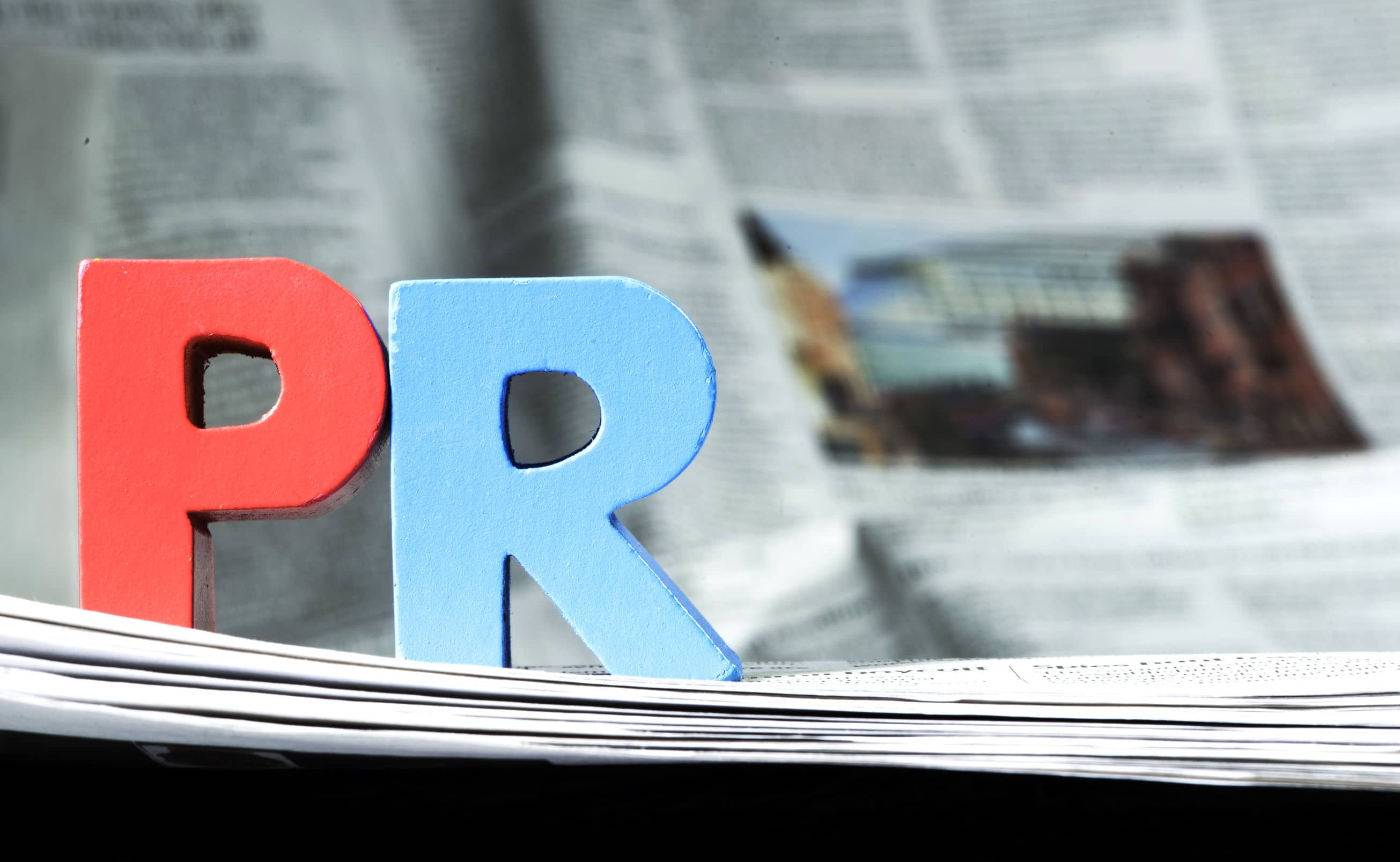 An image of the letters PR on top of a newspaper