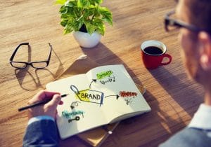 Man drawing in notebook diagram for social media marketing branding strategy.