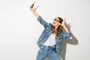 Young woman having a video conversation with her frind by cellphone in a big expressive move