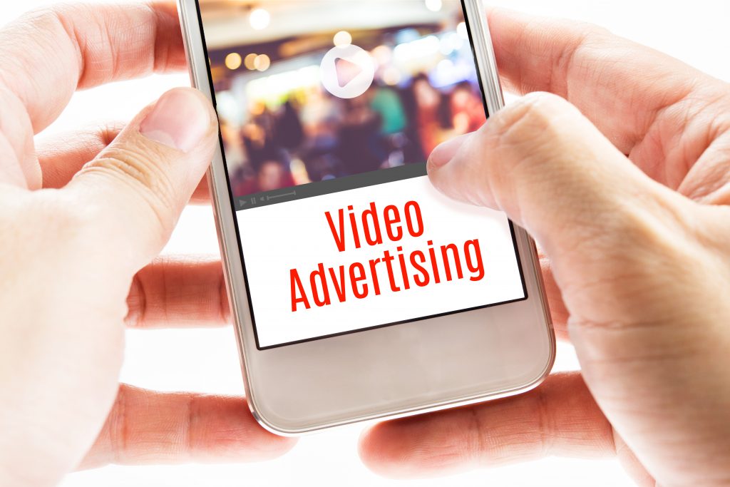 Two hands holding a iPhone with the words video advertising 