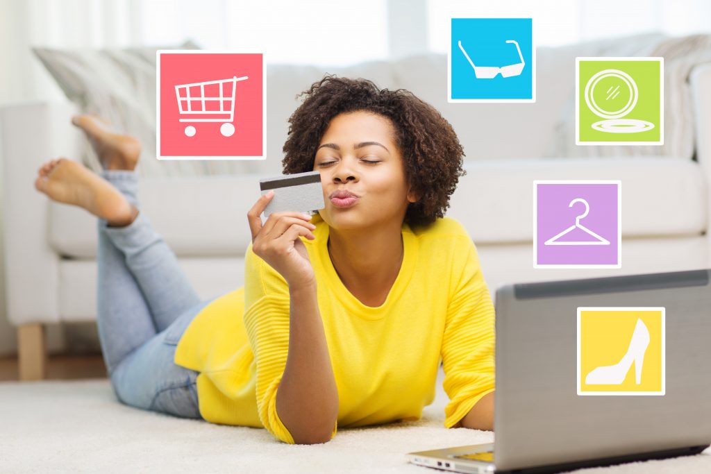 happy african woman with laptop and credit card