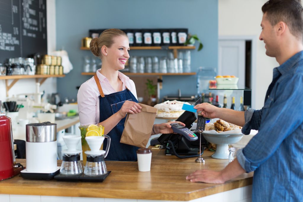 Woman asks man to leave her shop a review at the counter of a coffee shop. The goal is to improve her local SEO. 