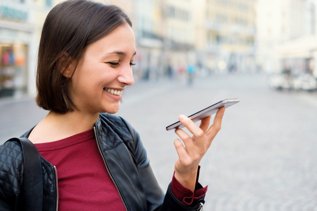 Woman on city streets picks up phone. Used to demonstrate that she is going to pick a shop based on the first page of Google results.