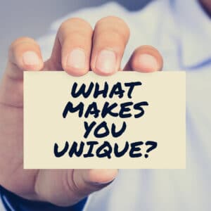 Man holding a question card to help with branding that reads, "what makes you unique?"